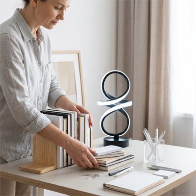 lampe de bureau spirale USB femme qui range les livres sur son bureau